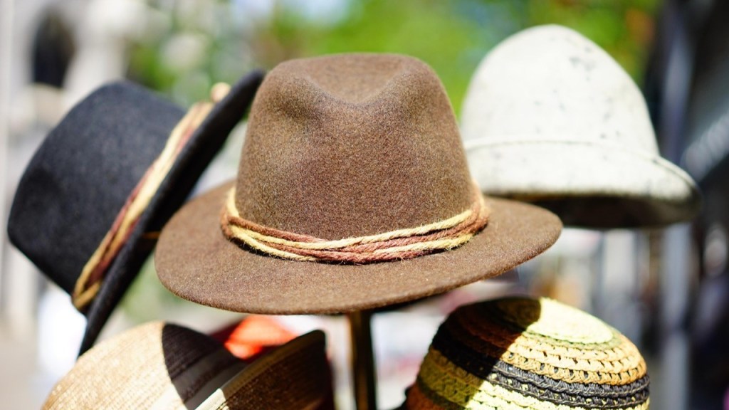 A variety of hats displayed on a stand, including a brown felt hat with a decorative band, a black hat, and straw hats in different styles.